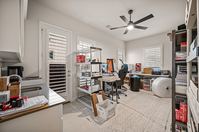 office space with ceiling fan, carpet floors, a sink, and visible vents