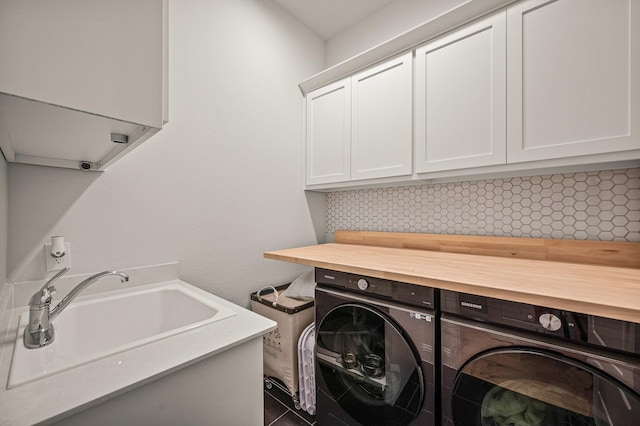 laundry room featuring cabinet space, a sink, and washing machine and clothes dryer