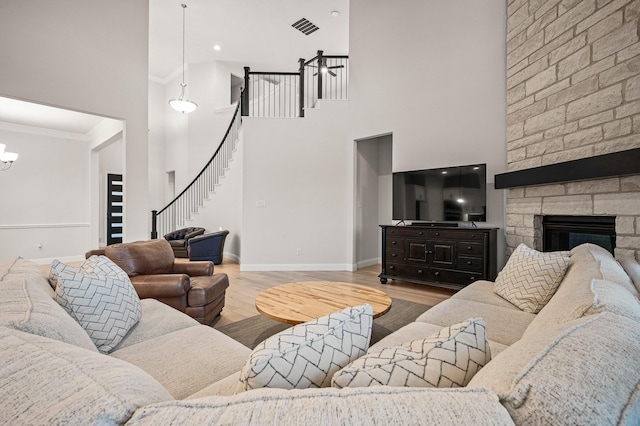 living room with visible vents, a fireplace, stairway, and wood finished floors