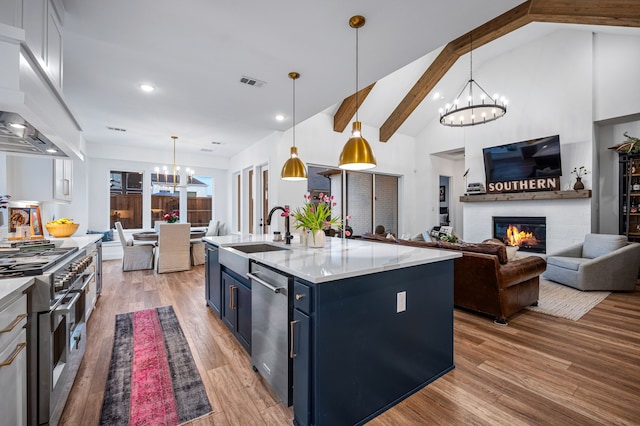 kitchen with blue cabinets, a chandelier, stainless steel appliances, and open floor plan