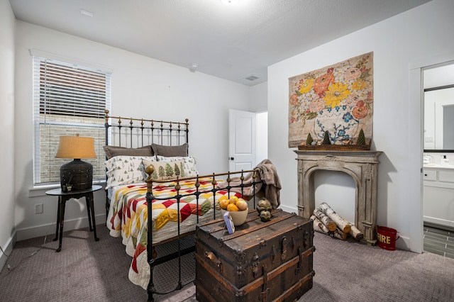 carpeted bedroom featuring visible vents, connected bathroom, and baseboards