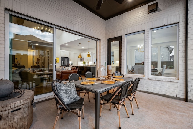 dining area with a towering ceiling, brick wall, and a ceiling fan