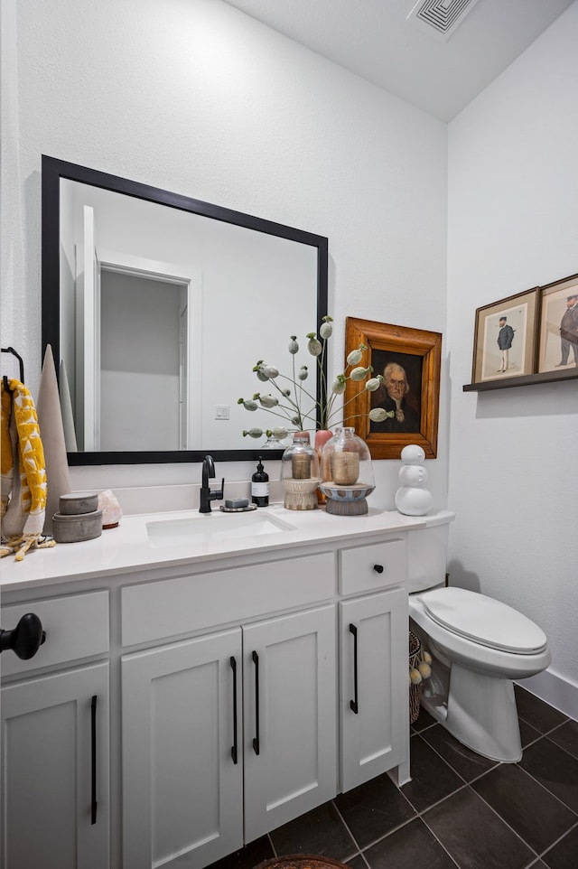 half bath with toilet, tile patterned flooring, vanity, and visible vents