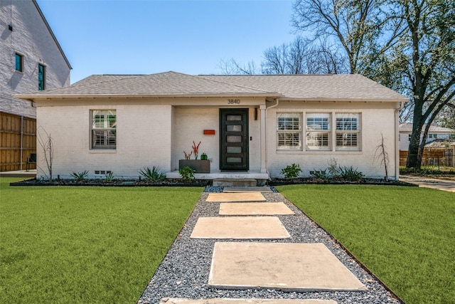 view of front facade featuring brick siding and a front yard