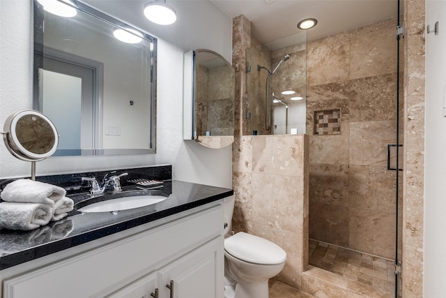 bathroom featuring vanity, toilet, and a shower stall