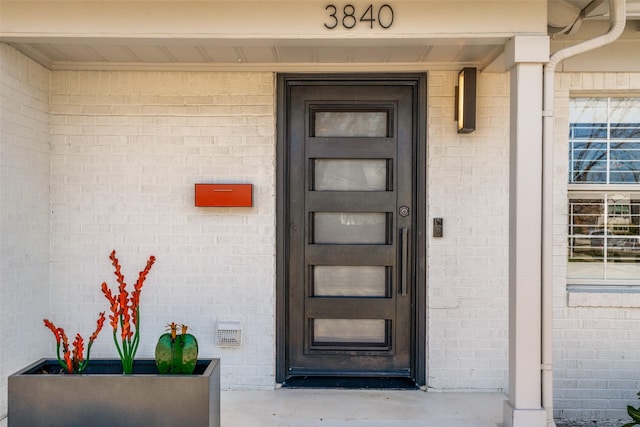 doorway to property with brick siding