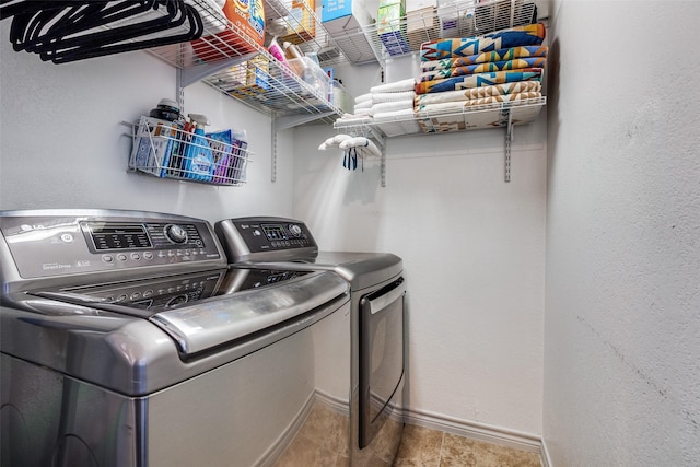 laundry room featuring washer and dryer, baseboards, laundry area, and a textured wall