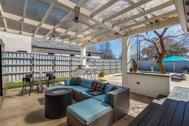 wooden deck featuring a patio, a fenced in pool, a ceiling fan, a fenced backyard, and an outdoor living space with a fire pit