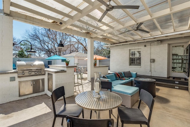 view of patio / terrace featuring a ceiling fan, fence, exterior kitchen, area for grilling, and outdoor dry bar