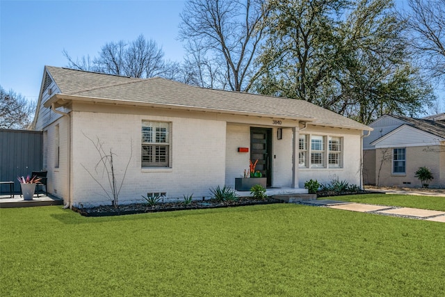 view of front facade featuring brick siding, roof with shingles, and a front lawn