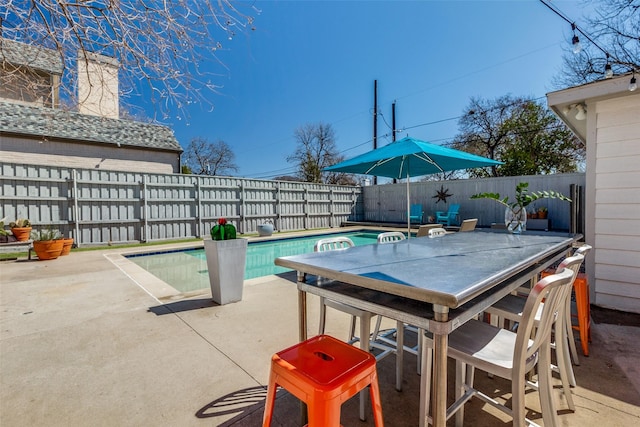 view of pool featuring a fenced backyard, outdoor dining space, a fenced in pool, and a patio