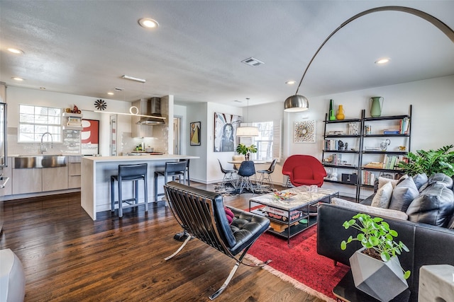 living area featuring dark wood-type flooring, plenty of natural light, recessed lighting, and visible vents