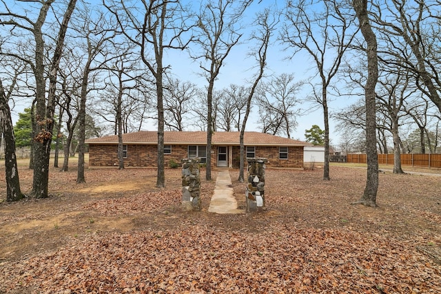 ranch-style house featuring brick siding and fence