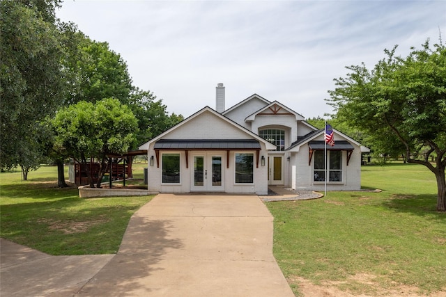 view of front of house featuring a front yard, french doors, and a chimney