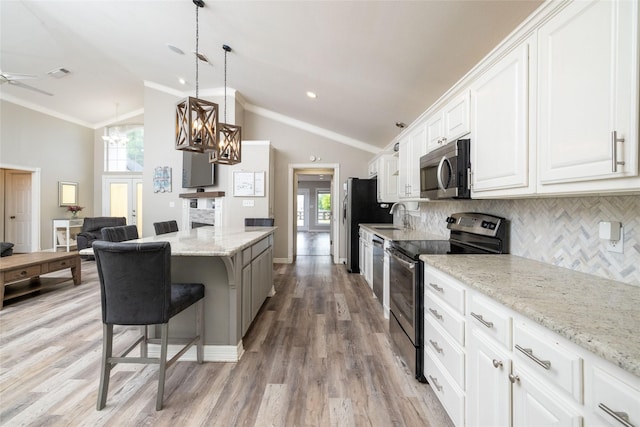 kitchen with visible vents, appliances with stainless steel finishes, white cabinetry, a sink, and a kitchen breakfast bar