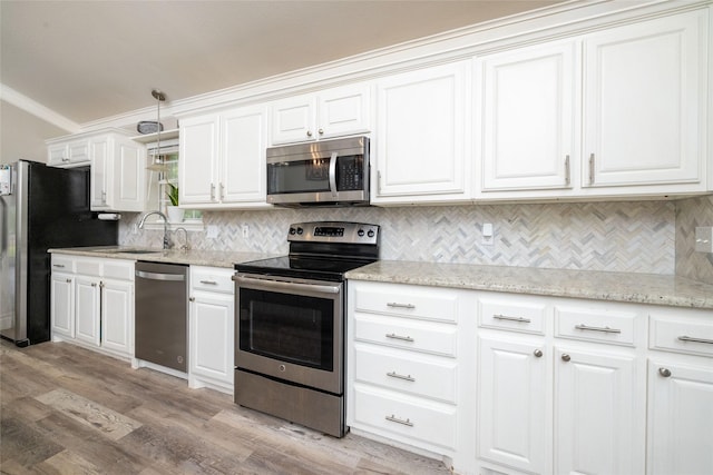 kitchen with stainless steel appliances, a sink, light wood-style floors, white cabinets, and crown molding