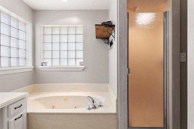 full bath featuring a tub with jets, a shower stall, and vanity