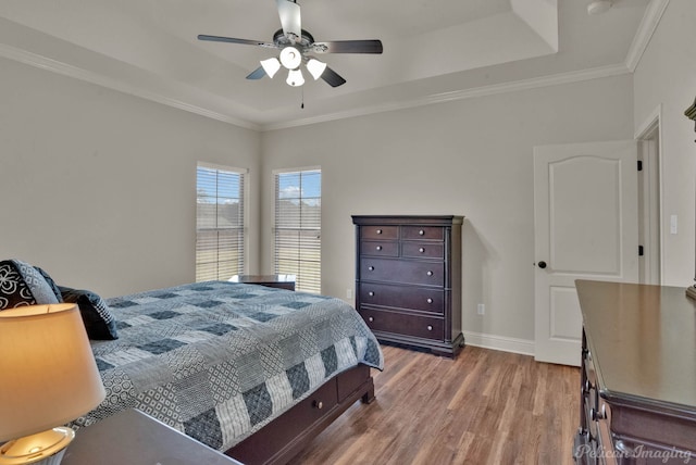 bedroom featuring crown molding, baseboards, ceiling fan, and wood finished floors