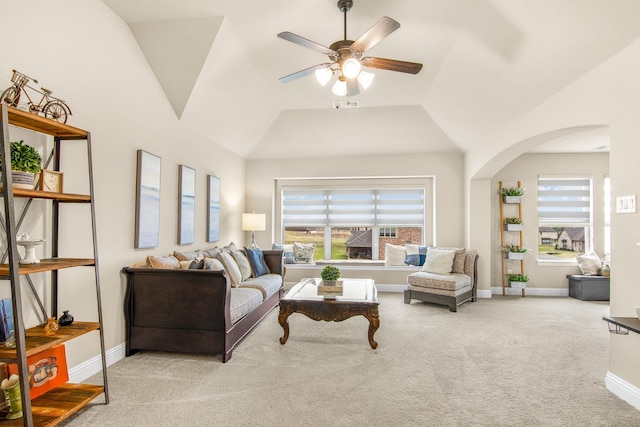 carpeted living area featuring a ceiling fan, arched walkways, plenty of natural light, and lofted ceiling