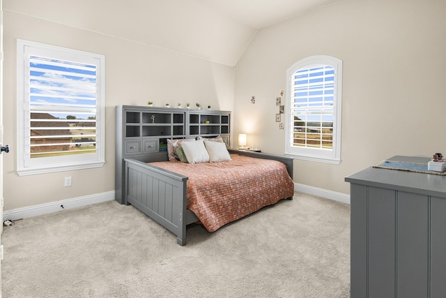 carpeted bedroom with vaulted ceiling and baseboards