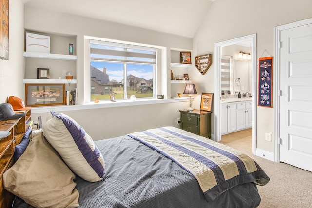 bedroom featuring lofted ceiling, baseboards, ensuite bathroom, and light colored carpet