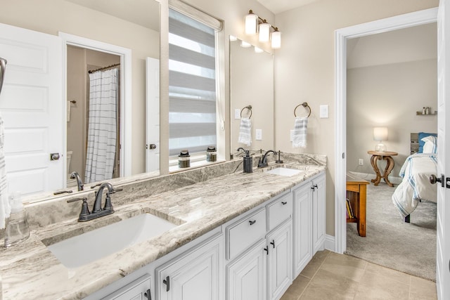 bathroom with connected bathroom, tile patterned flooring, a sink, and double vanity