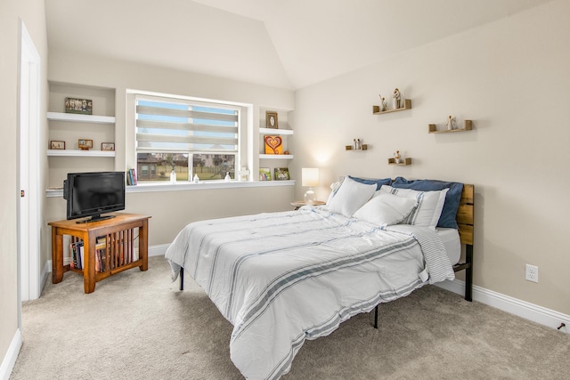 carpeted bedroom with baseboards and vaulted ceiling