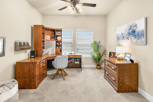 office space featuring light carpet, ceiling fan, and baseboards