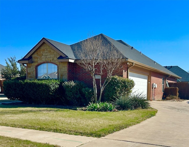 view of front of home featuring driveway, brick siding, stone siding, an attached garage, and a front yard