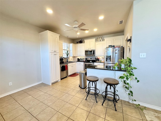 kitchen featuring a peninsula, white cabinetry, and stainless steel appliances