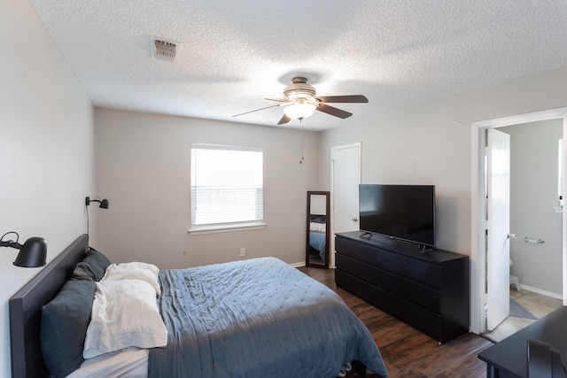 bedroom with ceiling fan, dark wood-style flooring, a textured ceiling, and visible vents