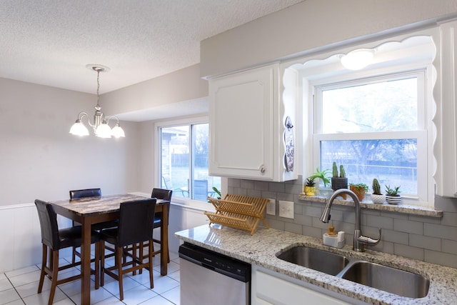 kitchen featuring white cabinetry, a sink, a textured ceiling, and stainless steel dishwasher