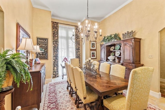 dining room with a notable chandelier, baseboards, and crown molding