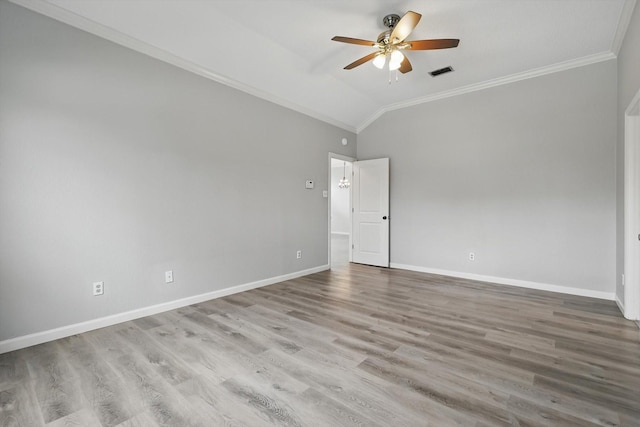 unfurnished room with crown molding, lofted ceiling, visible vents, wood finished floors, and baseboards