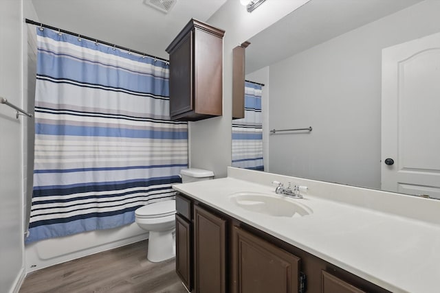 full bathroom featuring toilet, wood finished floors, visible vents, vanity, and shower / tub combo with curtain