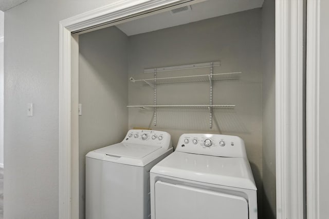 laundry room with laundry area, visible vents, and washing machine and clothes dryer