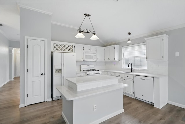 kitchen with white appliances, dark wood-type flooring, crown molding, white cabinetry, and a sink