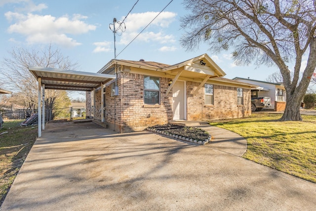 view of front of property featuring brick siding, fence, concrete driveway, a detached carport, and a front lawn