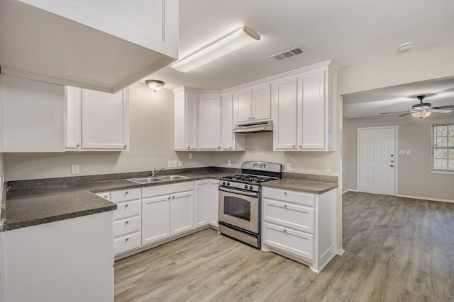 kitchen with dark countertops, visible vents, stainless steel range with gas stovetop, white cabinets, and under cabinet range hood