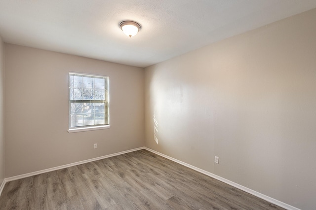 spare room featuring wood finished floors and baseboards