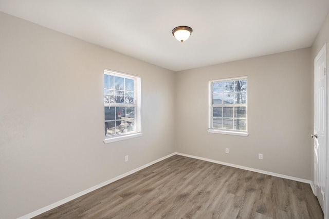 spare room featuring wood finished floors and baseboards