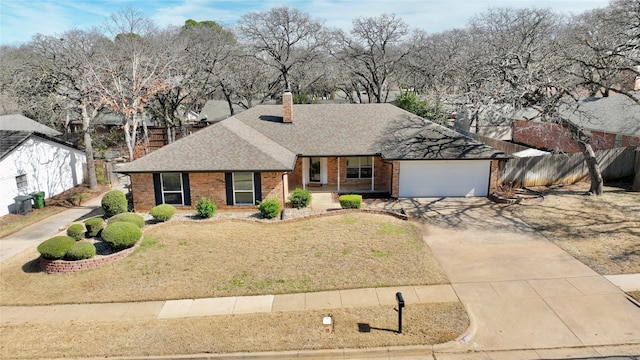 ranch-style house featuring an attached garage, brick siding, fence, concrete driveway, and a front yard