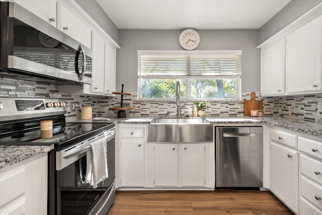 1803 Burr Oak St, Arlington, TX 76012 - kitchen featuring stainless steel appliances, a sink, decorative backsplash, and white cabinetry