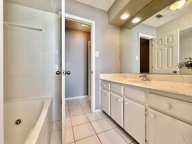 bathroom with baseboards, visible vents, tile patterned floors, a textured ceiling, and vanity