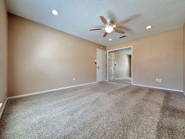 empty room with a textured ceiling, visible vents, and baseboards