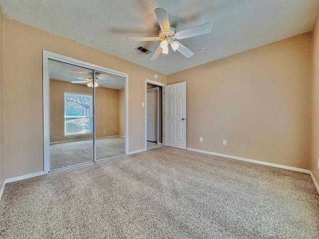 unfurnished bedroom featuring a textured ceiling, a closet, carpet, and baseboards