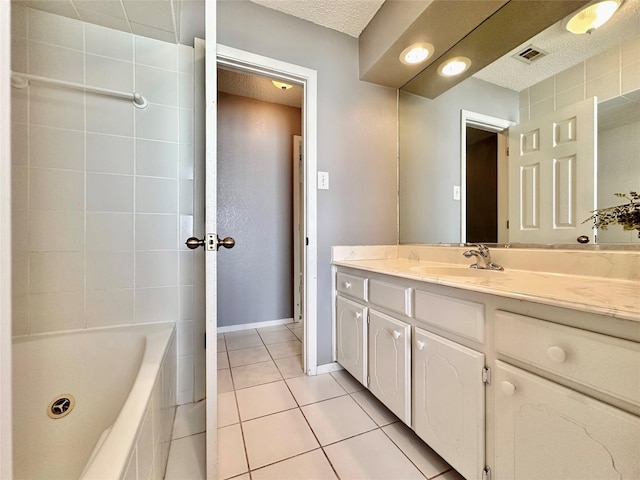 full bathroom featuring visible vents, a textured ceiling, vanity, baseboards, and tile patterned floors