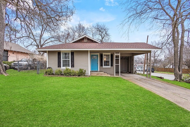 view of front of property featuring an attached carport, fence, concrete driveway, roof with shingles, and a front yard