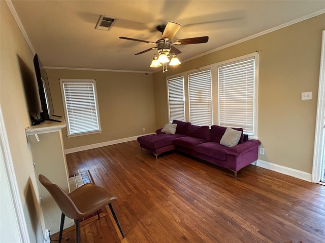 living area with baseboards, visible vents, wood finished floors, and ornamental molding