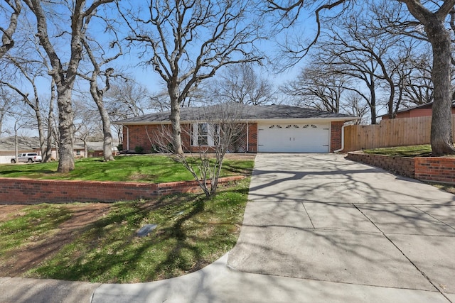 view of front facade featuring driveway, a garage, fence, a front lawn, and brick siding